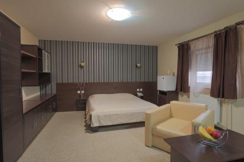 a hotel room with a bed and a chair at Prenociste Knez in Sombor