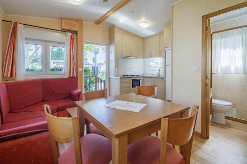 Una sala de estar con una mesa y un sofá rojo. en Bungalow C, en Pontevedra