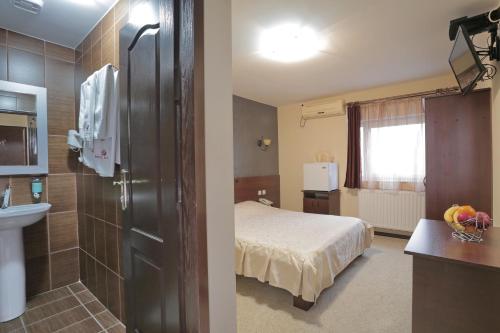 a hotel room with a bed and a bathroom at Prenociste Knez in Sombor