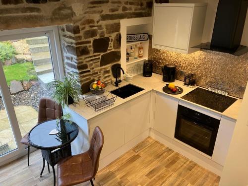 eine Küche mit Tisch und Arbeitsplatte in der Unterkunft Waterfront cottage Applecross Peninsula in Ardheslaig