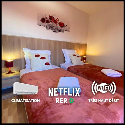 - 2 lits dans une chambre d'hôtel ornée de fleurs rouges dans l'établissement L'Escapade, Proche Carré-Sénart et Disneyland, à Combs-la-Ville