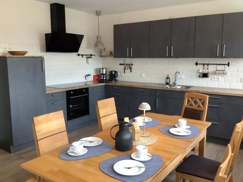 a kitchen with a wooden table and a dining room at Ferienwohnung Hümmling in Börger