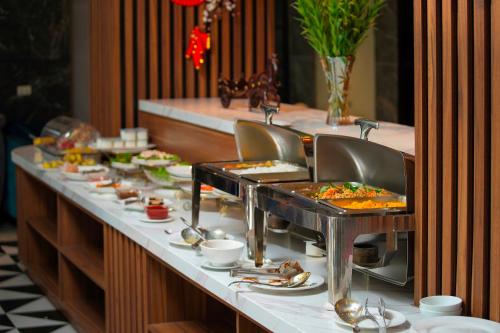 a buffet line with many plates of food at Hanoi Ping Luxury Hotel in Hanoi