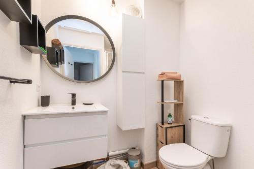 une salle de bain avec des toilettes blanches et un miroir dans l'établissement Le Cœur de Béziers - Maison climatisée à Béziers, à Béziers