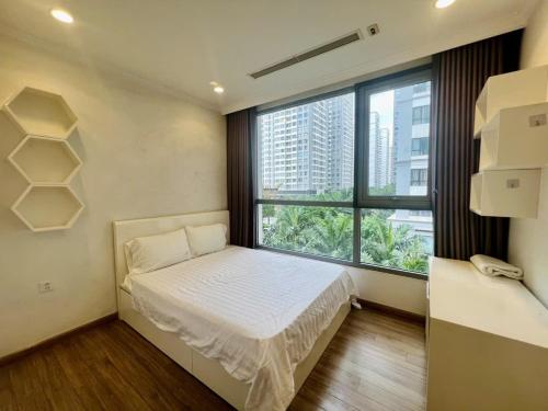 a bedroom with a bed and a large window at BOM HOMES- Vinhomes Timescity-3Br-Luxury Apt in Hanoi