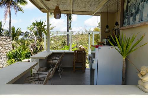 a patio with a table and chairs and a refrigerator at Gapul Penida in Nusa Penida