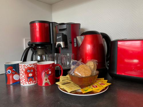 eine Theke mit Kaffeetassen und einem Teller Brot in der Unterkunft L'Escapade, Proche Carré-Sénart et Disneyland in Combs-la-Ville