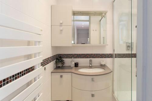 une salle de bain blanche avec un lavabo et un miroir dans l'établissement #57 Suite Notre Dame Central balcony & AC, à Nice