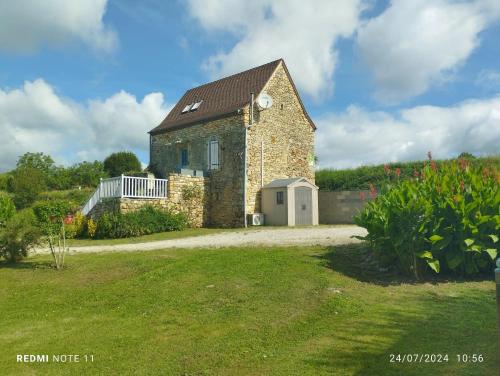 LoupiacにあるMaison charmante avec piscine à Loupiacの草原の古石造家