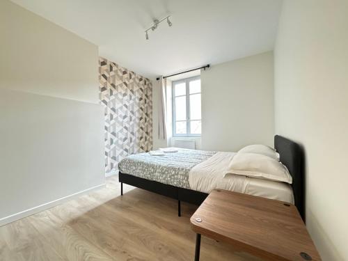 une chambre avec un lit et une table en bois dans l'établissement Appartement Neuf pour 4 Personnes au Cœur de Riom N6, à Riom