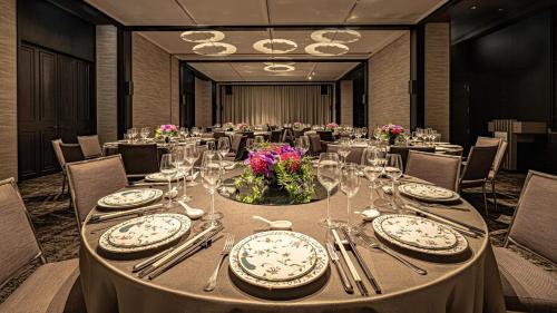 a dining room with a table with plates and utensils at 北投晶泉丰旅 Wellspring by Silks Beitou in Taipei