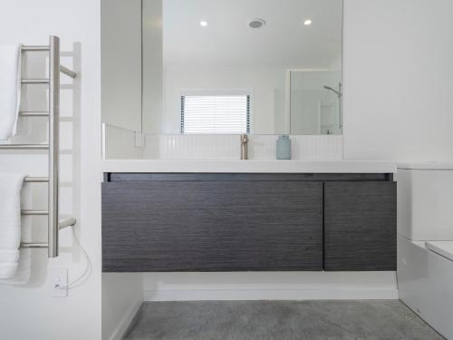 a bathroom with a sink and a mirror at Blue Skies - Whitianga Holiday Home in Whitianga