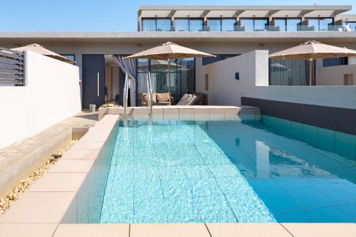 a swimming pool with umbrellas on top of a building at Galini Palace in Kolymvari