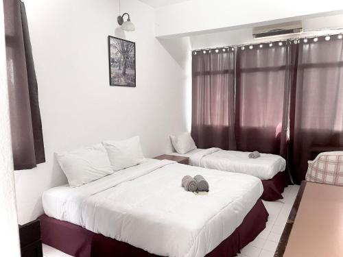 a hotel room with two beds and a window at Grand Star Hotel in Batu Ferringhi