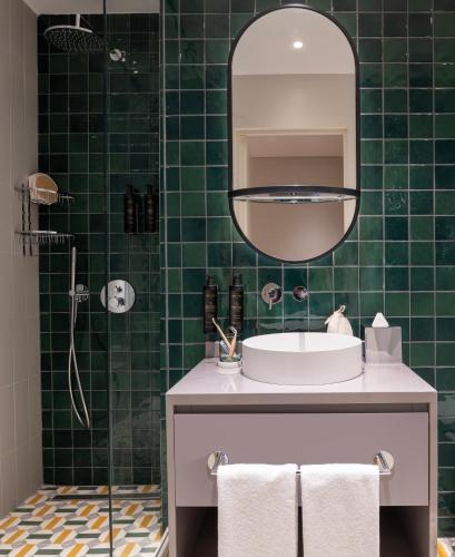 a green tiled bathroom with a sink and a mirror at Casa Foscolo Hotel, Istanbul, a Member of Design Hotels in Istanbul