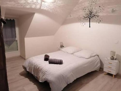 a bedroom with a bed with a tree on the wall at Gîte du Fournil in Plorec-sur-Arguenon