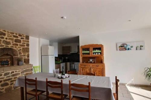 a kitchen with a table with chairs and a fireplace at Gîte du Fournil in Plorec-sur-Arguenon