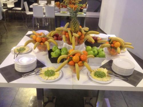 a table with plates of fruits and vegetables on it at A Point Arezzo Park Hotel in Arezzo