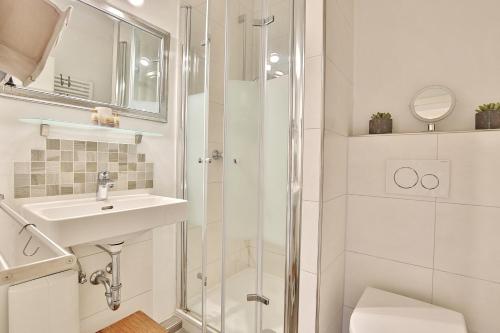 ein weißes Badezimmer mit Waschbecken und Dusche in der Unterkunft Seepark Seepark Appartement 36 in Scharbeutz