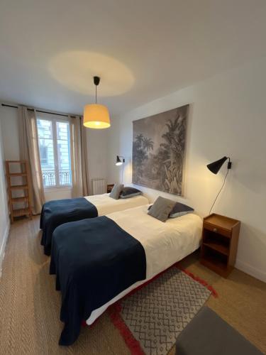 une chambre avec deux lits et une lampe dans l'établissement 3 PIECES PLEIN CENTRE, à Trouville-sur-Mer