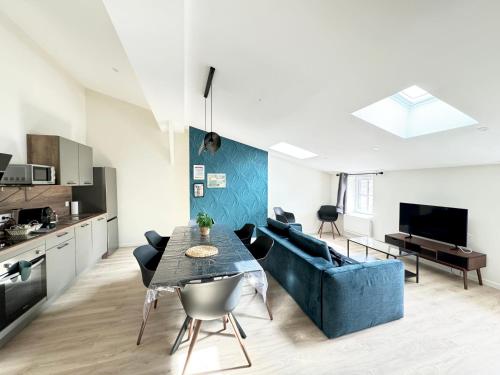 un salon avec un canapé bleu et une table dans l'établissement Escapade Confortable à Riom - 14 Couchages!, à Riom