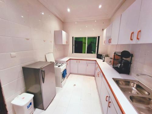 a small kitchen with white cabinets and a sink at Confortable Appartement près de la plage - BelAppart Mercure in Mpita