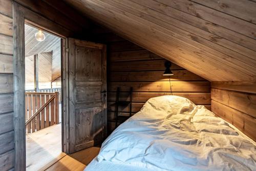 a bed in the attic of a log cabin at Nybyggd stuga, modern arkitektur - panoramautsikt in Idre