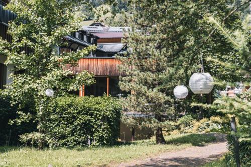 a house with trees in front of a building at Felbermayer Hotel & AlpineSpa-Montafon in Gaschurn