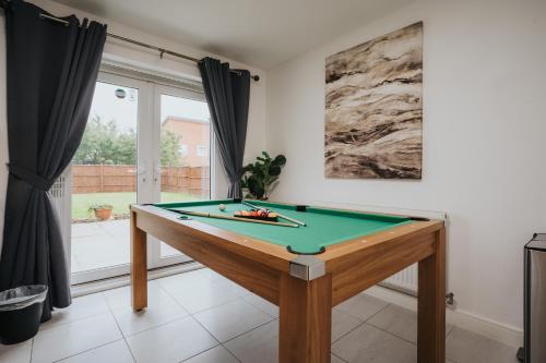 a billiard table in a room with a window at Pool Table - Coop Live Arena, Etihad & City stay in Manchester
