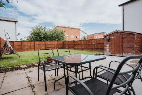 a patio with a table and chairs and a fence at Pool Table - Coop Live Arena, Etihad & City stay in Manchester