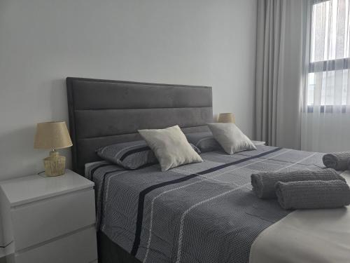 a bedroom with a large bed with a black headboard at Aspasianus 1-Bedroom Pool View Apartment in Caesar Resort in Perivolia tou Trikomou