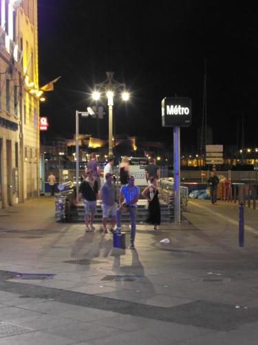 a group of people walking down a street at night at Hôtel Beauséjour in Marseille