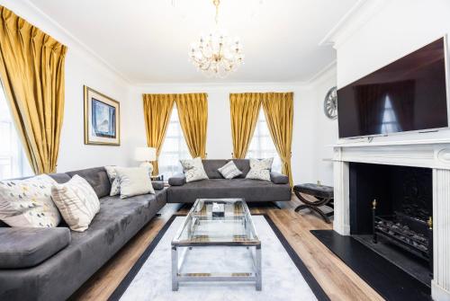 a living room with a couch and a fireplace at CARLTON COURT - MAYFAIR in London