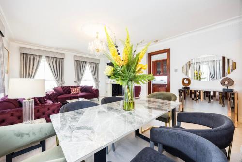 a living room with a table with a vase of flowers at CARLTON COURT - MAYFAIR in London