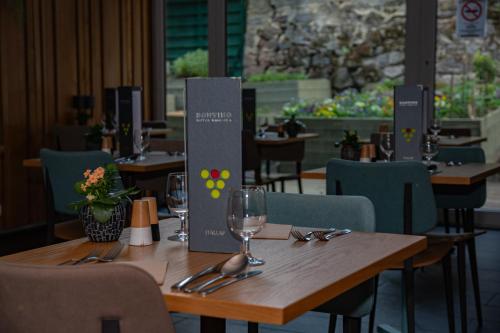 a wooden table in a restaurant with glasses and silverware at Hotel Bonvino Badacsony in Badacsonytomaj