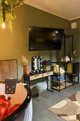 a living room with a desk and a tv at XiHouse Bed & Apartments - Iglesias in Iglesias