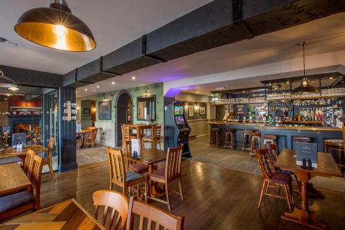 a restaurant with tables and chairs and a bar at The Howard Arms in Brampton