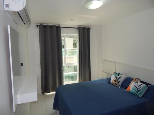 a bedroom with a blue bed and a window at Charmoso e confortável 1 quarto/frente Mar - Mandai / Inicio da praia do Forte - CF07 in Cabo Frio