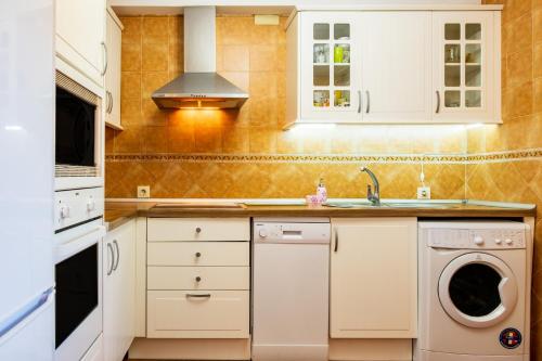 a kitchen with a sink and a dishwasher at La Covacha in Solana de ávila