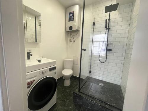 een badkamer met een douche, een toilet en een wastafel bij Uliha street sea side apartment in Liepāja