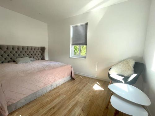 een slaapkamer met een bed, een stoel en een raam bij Uliha street sea side apartment in Liepāja