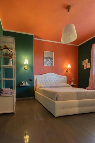 a bedroom with an orange and green wall at XiHouse Bed & Apartments - Iglesias in Iglesias