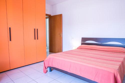 a bedroom with orange and red cabinets and a bed at Ficus Pineto Vacanza in Pineto