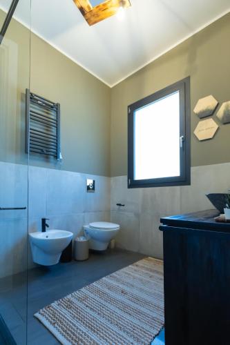 a bathroom with two toilets and a window at XiHouse Bed & Apartments - Iglesias in Iglesias