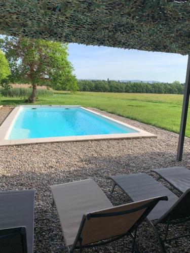 - une piscine dans une cour avec des chaises et un parasol dans l'établissement Mas des Lubières, à Saint-Rémy-de-Provence