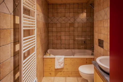une salle de bain avec une baignoire, des toilettes et un lavabo dans l'établissement Chalet Grand Mouflon, aux Gets