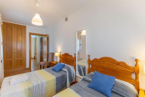 a bedroom with two beds with blue pillows at Casa Rural Arbana in Segovia