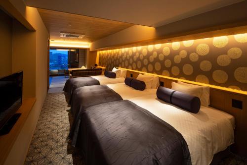 a row of beds in a hotel room at Yumoto Konpira Onsen Hananoyu Kobaitei in Kotohira