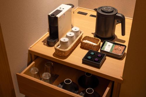 a cabinet with a phone and other items on it at Yumoto Konpira Onsen Hananoyu Kobaitei in Kotohira