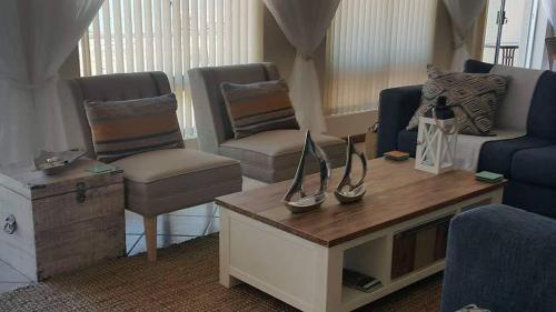 a living room with a couch and a table at Albatros Nes 49 Van Spilberg Road Saldanha in Saldanha